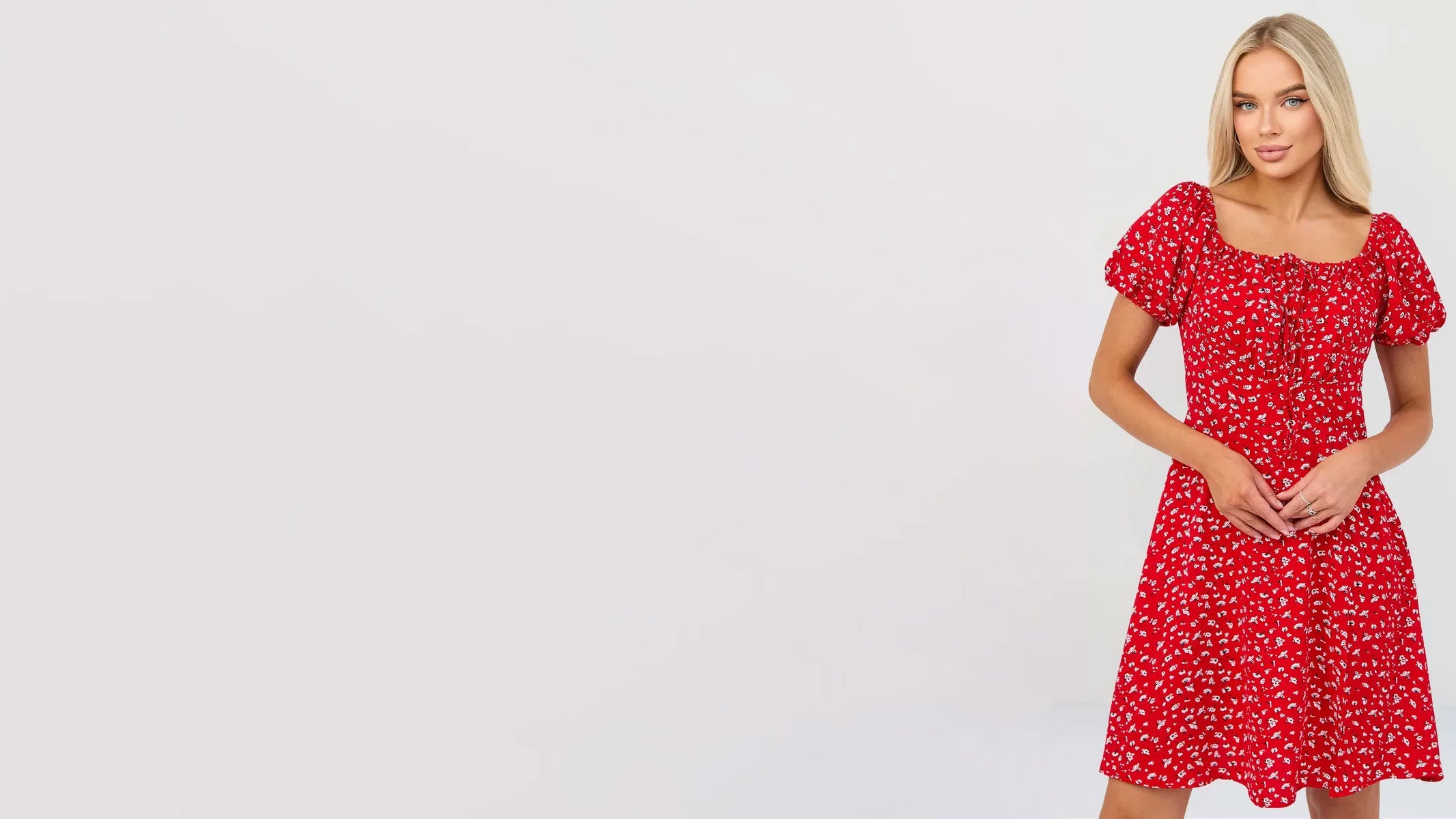 Model wearing a vibrant red floral dress with short sleeves, styled against a clean white background.
